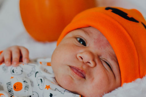 Baby mit orangener Mütze Baby Mütze